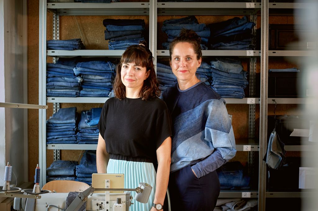 Die Gründerinnen Dr. Constanze Klotz und Hanna Charlotte Erhorn stehen vor einem Regal mit Jeans